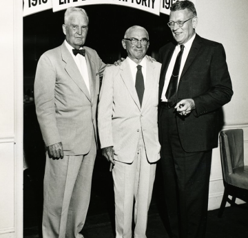 Older Osborn in between two men smiling 