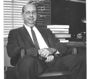 Donald MacKinnon sitting at desk 